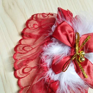 Dettaglio ravvicinato del bordo superiore della calza natalizia con pizzo rosso e fiocco.