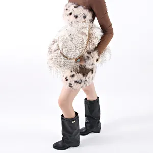 Detailed view of an oversized fluffy cloud handbag featuring animal print fur and gold chain