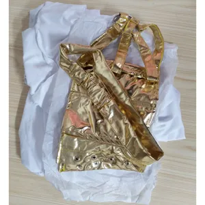 Metallic gold costume top detail, featuring shiny fabric and metal eyelet decorations.