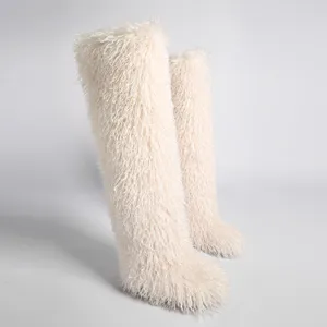 Vista lateral detallada de botas de nieve de piel sintética crema de 72 cm de largo