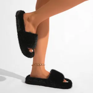 Vue détaillée de pantoufles en fausse fourrure noire au style punk y2k duveteux