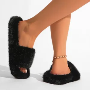 Vue rapprochée de pantoufles noires en fausse fourrure au style punk Y2K très tendance
