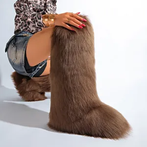 Gros plan de bottes de neige luxueuses en fausse fourrure de renard marron, hauteur genou.