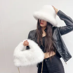 Detail shot of soft white faux fur bucket hat and matching hobo bag with gold chain