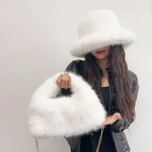 Detailed shot of a luxury white faux fox fur bucket hat and matching hobo bag set on model