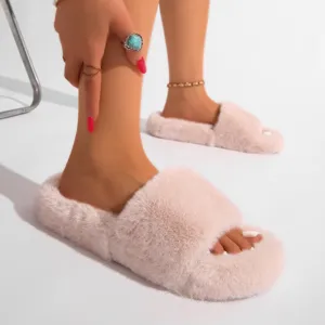 Gros plan détaillé de chaussons en fausse fourrure rose avec bride en peluche et semelle PVC