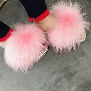 Detailed view of fashionable pink fluffy slippers featuring raccoon fur and silver PVC soles