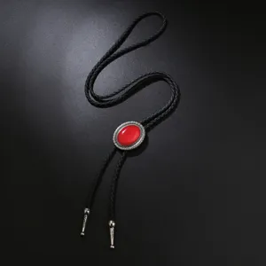 Vintage bolo tie featuring a red gemstone set in silver metal with black braided cord