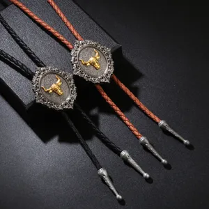 Vintage western cowboy bolo tie featuring a gold bull head medallion and leather cord