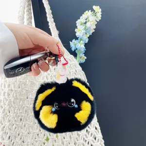Detail van een schattige pluche kattenhanger met konijnenbont aan een Mercedes-sleutel