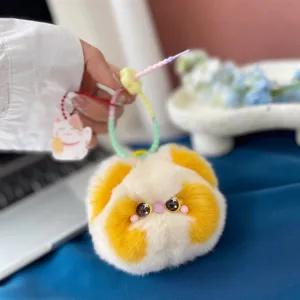 Close-up van een schattige geel-witte pluche Dudu Cat-bedel gemaakt van Rex konijnenbont