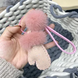 Detailed view of cute pink mink fur mitten keychain with glitter and soft pom pom
