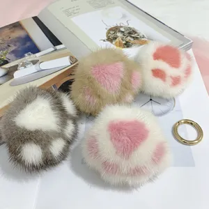 Gedetailleerde weergave van pluizige nertsbont kattenpoot hangers in diverse pastelkleuren goud