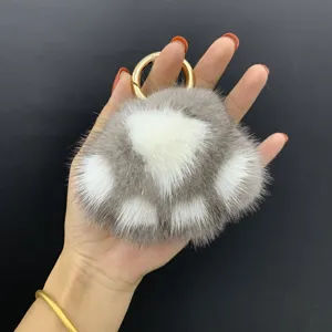 Gedetailleerde weergave van een zachte nertsbont kattenpoot sleutelhanger met goudring.