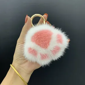 Detail van een zachte nertsbont kattenpoot sleutelhanger met een gouden metalen ring