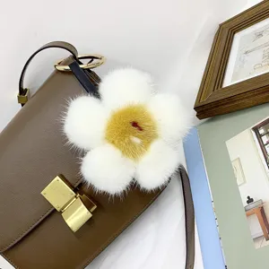Detailansicht eines weichen Nerzpelz-Blumenanhängers an einer braunen Lederhandtasche