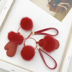 Close-up of red mink fur mitten and slipper bag charms with patent leather straps