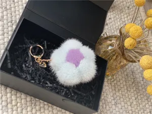 Close-up of a soft mink fur flower keychain charm presented in a black gift box for her