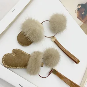 Detail shot of cute mink fur mitten and slipper bag charms with leather straps