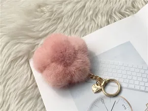 Elegant pink mink fur flower-shaped keychain with gold hardware and engraved heart charm