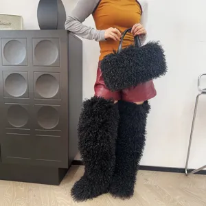 Dettaglio di una borsa tote in finta pelliccia nera riccia con stivali coordinati