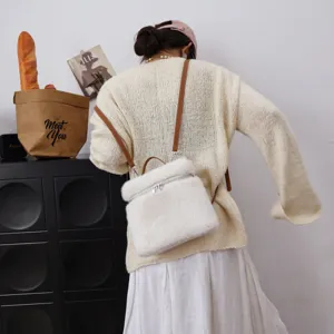 Model trägt einen weichen weißen Kunstpelz-Rucksack mit eleganten Lederriemen