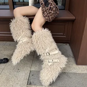 Détail de bottes punk en fausse fourrure de mouton beige avec sangles à boucle