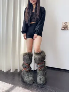 Close-up of Y2K style faux fur snow boots with punk buckle straps worn by a model