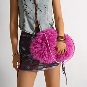 Detail of pink faux shearling fuzzy cloud bag held by a model as a stylish fashion clutch