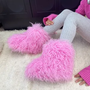 Gros plan détaillé des bottes de neige roses en fausse fourrure pour enfants sur tapis