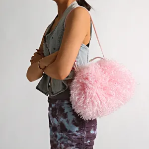Close-up detail of pink faux Mongolian lamb fur cloud bag on a model
