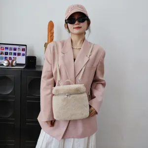 Detailansicht des beigefarbenen Kunstfell-Rucksacks an einem Modell in Rosa