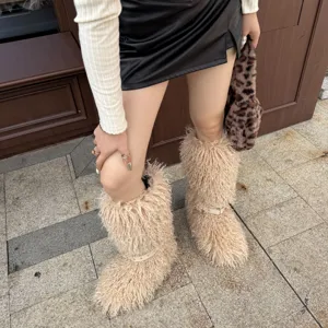 Vue détaillée des bottes beiges en fausse fourrure avec sangles à rivets et texture douce.