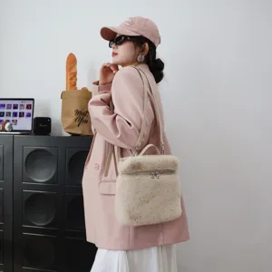 Model trägt einen beigen Plüschrucksack aus Kunstpelz mit rosa Blazer.