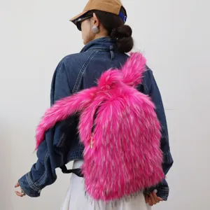 Back view of a woman wearing a vibrant pink faux fur rabbit ear backpack with long hair.