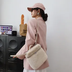 Seitenansicht des flauschigen beigen Kunstfell-Rucksacks getragen über einem rosa Blazer.