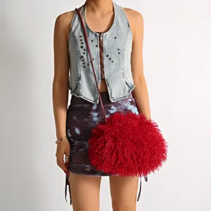 Red faux Mongolian sheep fur crossbody bag shown on a model for scale and texture.