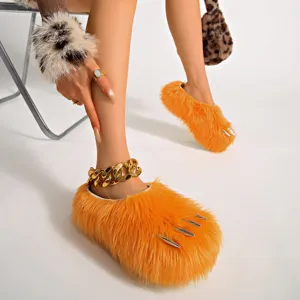 Close-up of bright orange furry paw-shaped slippers featuring silver claw details