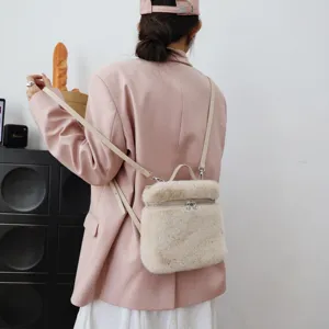 Detailansicht eines flauschigen Rucksacks aus Pelzimitat in Creme mit rosa Blazer