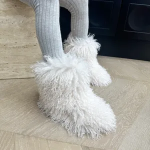 Vue détaillée de bottes blanches en fausse fourrure pour enfants dans un intérieur