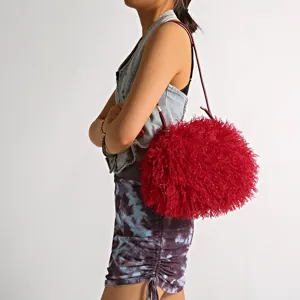 Fashionable red fluffy faux sheep fur underarm bag shown in a side view on model