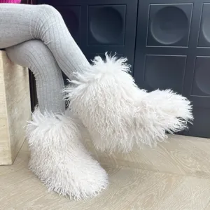Vue détaillée de bottes en fourrure blanche et moelleuse pour enfants sur un parquet