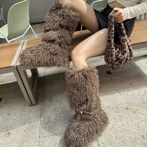 Vue détaillée de bottes de neige en fausse fourrure bouclée marron avec boucles en métal