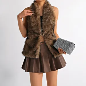 Model wearing a brown faux fur halter neck vest with a pleated leather skirt.