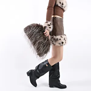 Detailed side view of large brown and white faux fur cloud bag held by a model