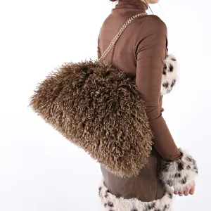 Large brown curly faux fur cloud bag with gold chain strap on model.