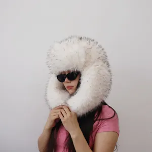 Close-up of a fluffy white faux fur trapper hat with black tips worn by a model.
