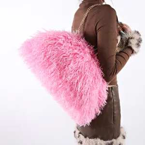 Detailed view of large pink fluffy cloud bag with sheep fur texture on model's shoulder