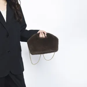 Λεπτομερής προβολή καφέ τσάντας από τεχνητή γούνα με χρυσή αλυσίδα