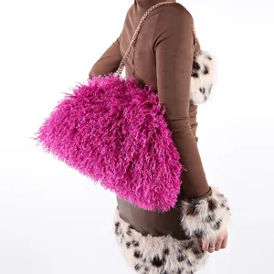Detailed view of large magenta fuchsia fluffy faux fur cloud bag with gold chain strap.